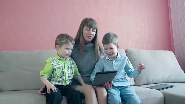 Mother and Two Sons Playing with Tablet