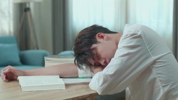 Close Up Of Asian Man Student Sleeping While Reading A Book At Home