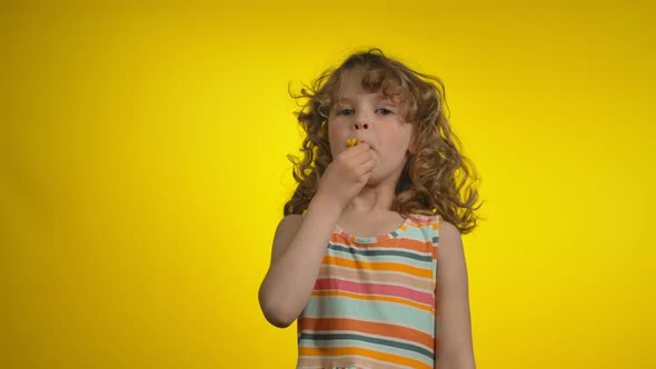 Little Girl with Curly Hair is Blowing in a Whistle and Making a No Gesture