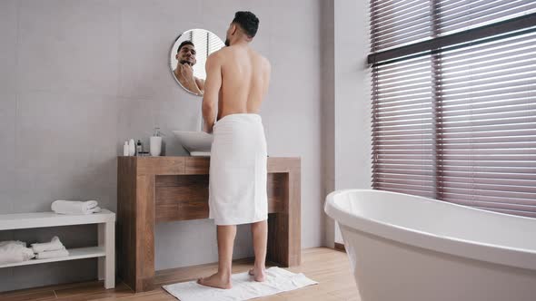 Full Length View Arabic Naked Muscular Athlete Indian Man with Towel on Hips Looking at Mirror in