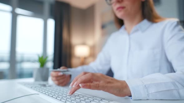 Female Hands Typing Credit Card Number on Computer Keyboard