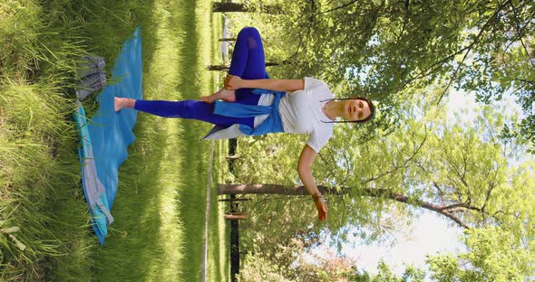 A 35 Year Old Woman Practices Yoga in a City Park