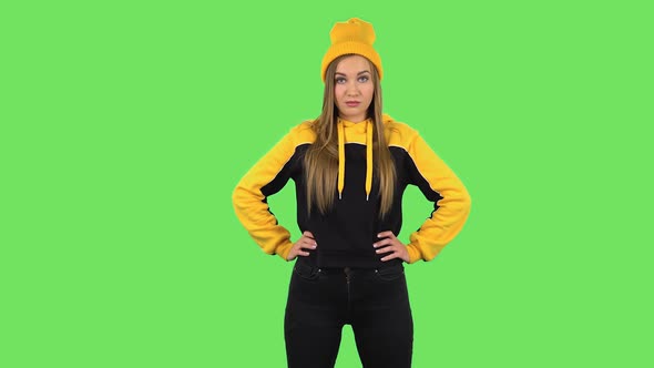 Modern Girl in Yellow Hat Stands Angrily and Crosses Her Arms Over Her Chest. Green Screen