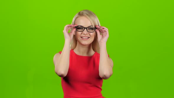 Girl Puts on Glasses with Black Rim, Green Screen Studio