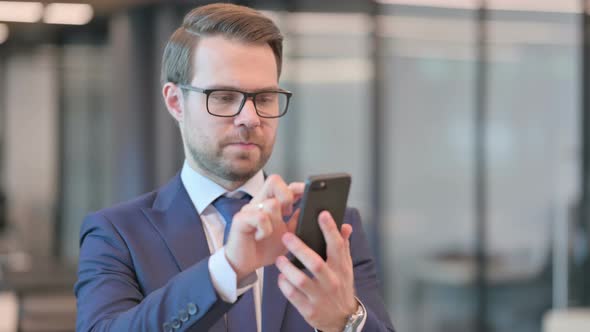 Portrait of Businessman Browsing Internet on Smartphone