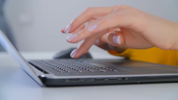 Young woman working on modern notebook computer in closeup 4k video