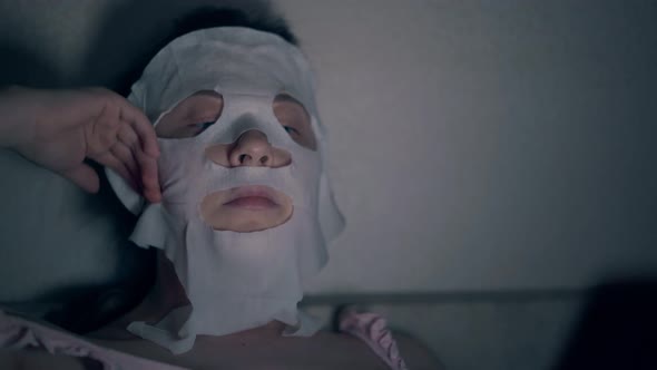 Beauty Salon Visitor in White Regenerating Sheet Mask Close