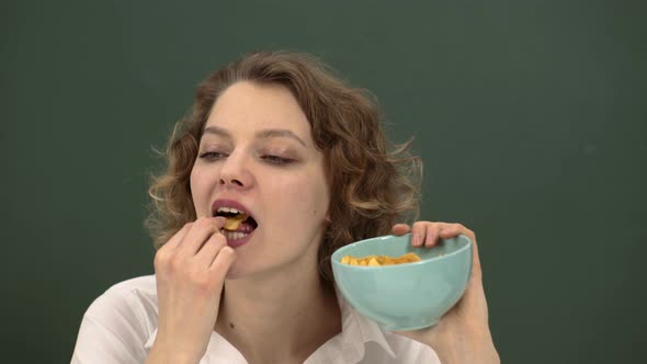 Female Student Eating Chips. Woman Eating Crispy Chips Snack.