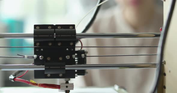 Young students looking at the 3D printer printing a prototype