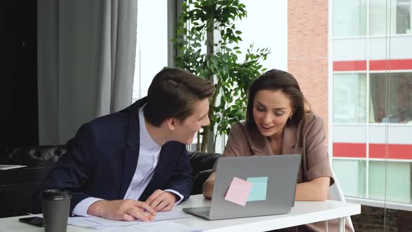 Happy smiling man and woman resting after work in modern office. 