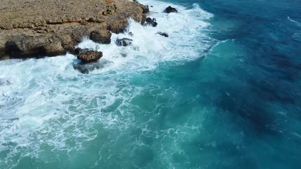 Rocky Coastline Cliffside with Blue Mediterranean Sea Ocean Storm Wave at Sunny Day Cyprus