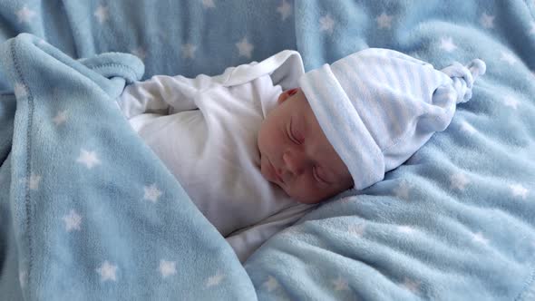 Medium Plan of Newborn Baby Face Portrait Early Days in Macro Sleeping On Blue Star Background