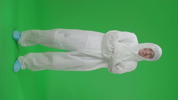 Full Body Of Asian Male Wearing Protective Uniform Ppe Pose With Arms Crossed In Green Screen Studio