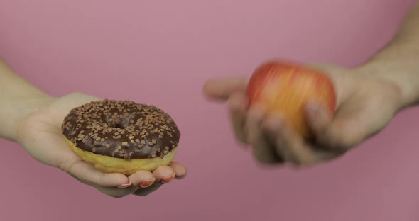 Hands Holds Donut and Apple. Choice Donut Against Apple. Healthy or Junk Food