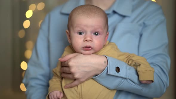 Young Mother Holding a Newborn Baby Boy in Her Arms