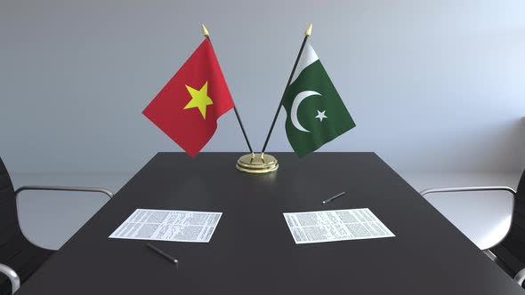 Flags of Vietnam and Pakistan and Papers on the Table alt