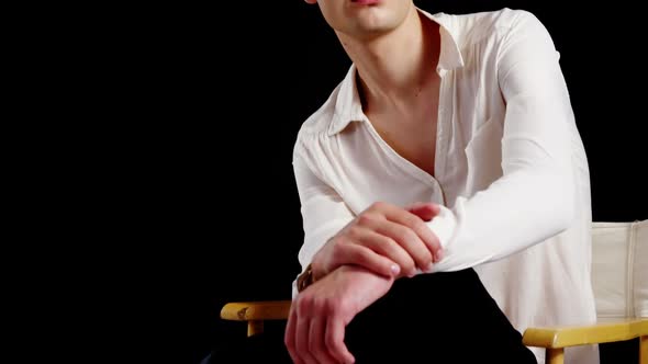 Androgynous man posing against black background