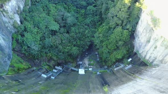 Aerial shot of Dam moving towards forest at the bottom of the dam. New Zealand