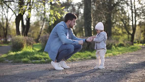 Adorable Little Gilr Spend Time with Her Father. Dad and Daughter Walk in the Park. Stylish Family