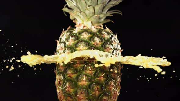 Fresh Pineapple Fruit Squirting and Burst with Juice in Slow Motion in Black Background