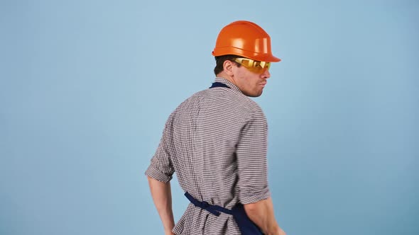 Young Man Worker in Safety Clothes Hard Hat and Protective Goggles