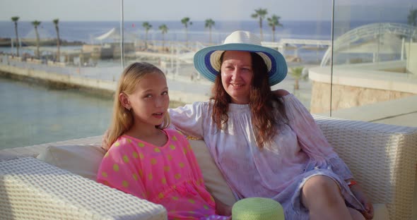 Mother and Daughter Sitting and Talking at Tropical Resort