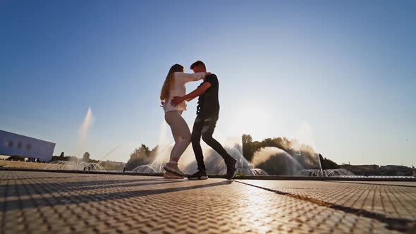 Playful dancing couple. Couple dancing on the embankment of the river