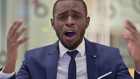 Portrait of Disappointed African Businessman Reacting to Loss