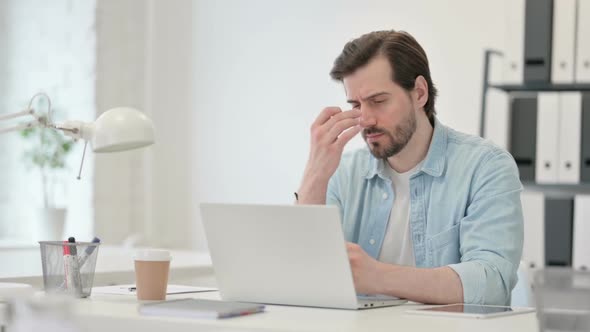 Man with Headache Working on Laptop