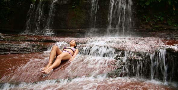 Girl With Bikini Lying Down In Waterfall