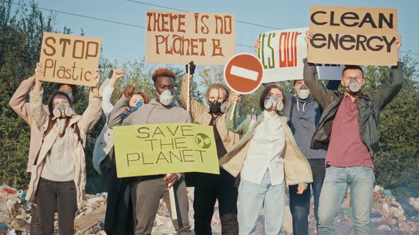 Group of Young Volunteers in Gas Masks With a Poster Calling To Take Care of the Environment