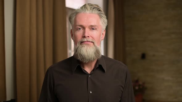 The emotion of surprise and fear shown by a gray-haired bearded adult man