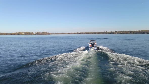 Person wakeboarding behind a boat on a perfect summer afternoon in Lake Minnetonka Minnesota, enjoy