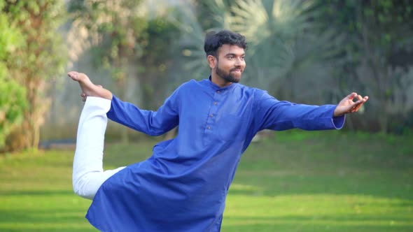 Indian man doing Natarajasana or Lord of the Dance Pose or Dancer Yoga Pose in Kurta Pajama