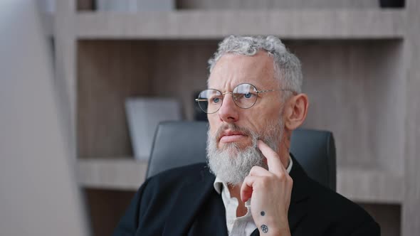 Close Up Portrait of Pensive Mature Grey Haired Businessman in Eyeglasses Thinking Over Problem