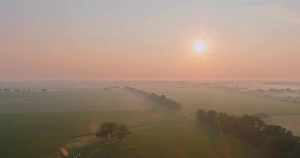 Rural Autumn Morning Landscape at Sunrise with Field in a Foggy