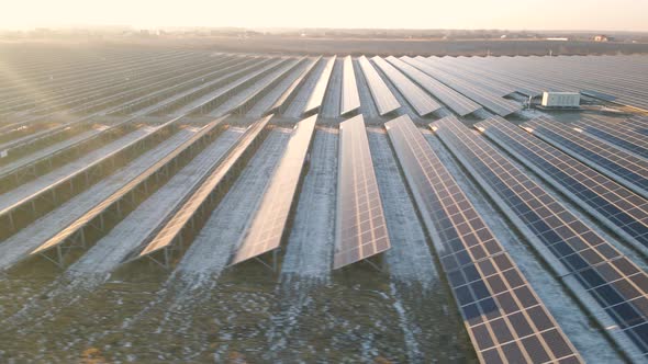 Aerial Drone View of Large Solar Panels at a Solar Farm at Bright Sunset in Early Winter