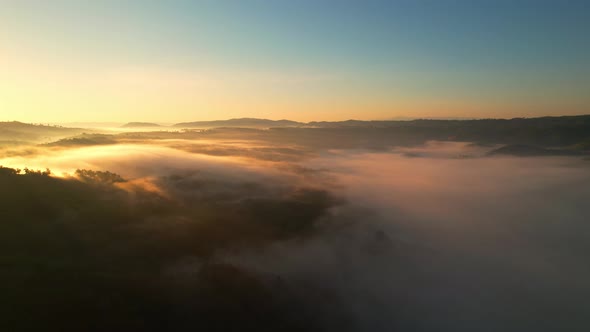 Aerial view of sunrise with fog above mountains