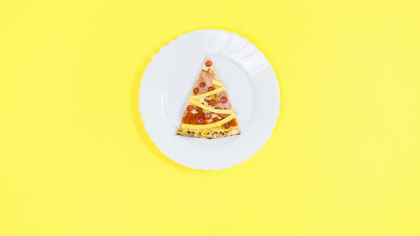 On white plate is piece of pizza, which is decorated with cheese like Christmas tree.