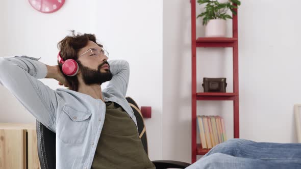 Young Adult Hipster Man Relaxing at Workplace