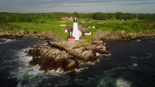 Aerial of lighthouse and villas on the beautiful green sea coast