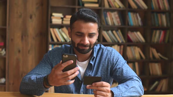 Young Handsome Indian Freelancer Man Using Smartphone for Online Payment