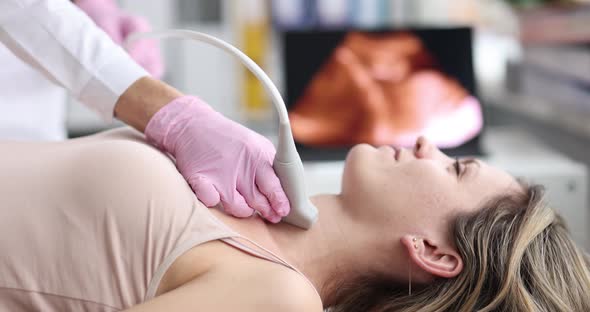 Doctor Diagnoses Ultrasound of Thyroid Gland of Patient in Clinic