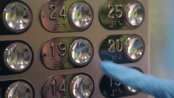 Hand in a Transparent Glove Pushing the Elevator Button. Personal Protection Against Viruses