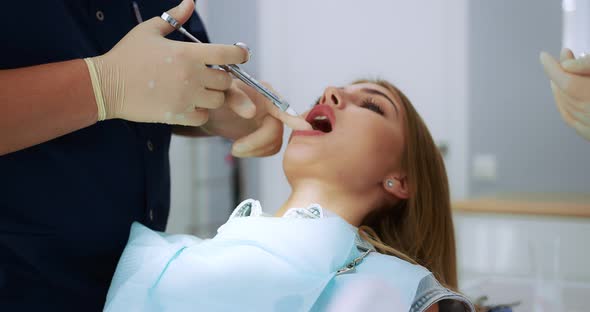 Dentist Gives an Analgesic Injection Into the Tooth of a Beautiful Woman