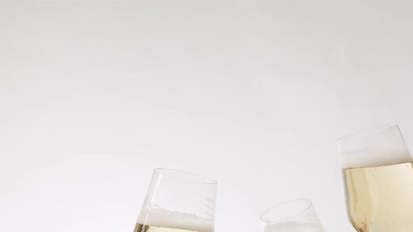 Three Glasses of Champagne Approach Collide on a White Background