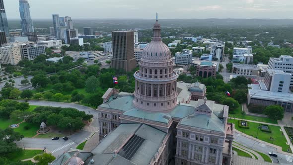 Aerial orbit of Texas State Capitol building and dome in Austin Texas. TX skyline in distance. Home