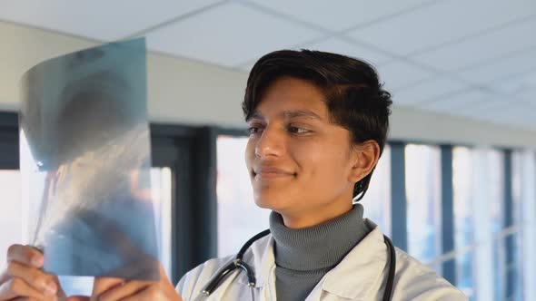 Indian Doctor or Intern Examines Xray of Lungs Holding It in Hands Indoors