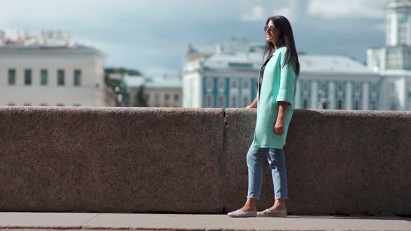 Fashion Smiling Woman Relaxing Having Positive Emotion at Cityscape Architecture Background