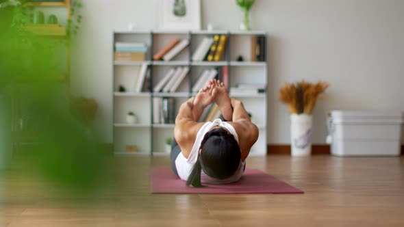 Athletic Asian woman practice yoga bow or dhanurasana pose